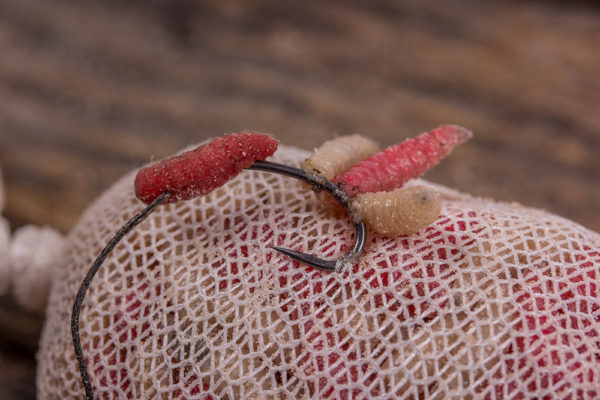 5. Zapíchněte háček velice opatrně do síťky a přitom ponechte volnou část návazce. Nasměrujte hrot háčku ven směrem od krmení, ovšem jinak skrytý v síťce, aby bylo zachováno jeho maskování. 